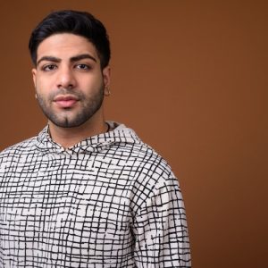 young-handsome-indian-man-against-brown-background_251136-45015